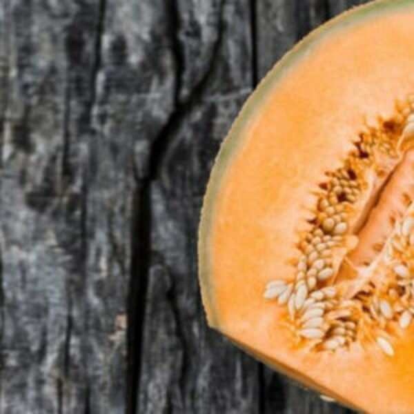 Fresh Muskmelon kept on a wooden table, muskmelon seeds.