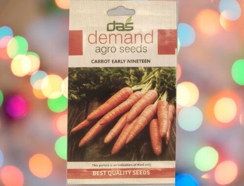 A packet of Demand Agro Carrot Early Nineteen Seeds kept against a colourful light background