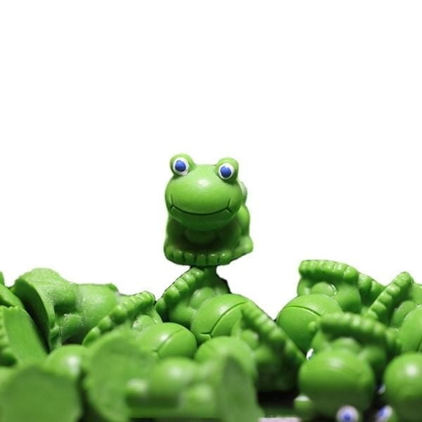 A cute Miniature Toy Frog kept on another Miniature Toy Frog.
