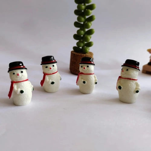 Four snowmen standing besides each other.