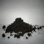 Vermi Compost kept against a white background in a heap.