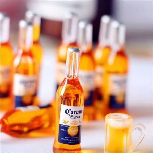 A Miniature Beer Bottle with Beer Mug beside it with several miniature beer bottles in the back ground.
