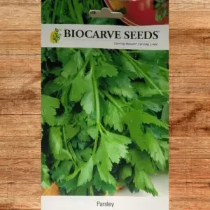 This is an image of a packet of Biocarve Parsley Seeds kept on a wooden platform.