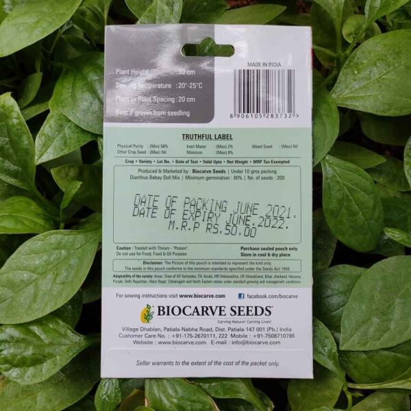 Backside picture of Biocarve Dhianthus Baby Doll Mix Seeds packet with leaves in background