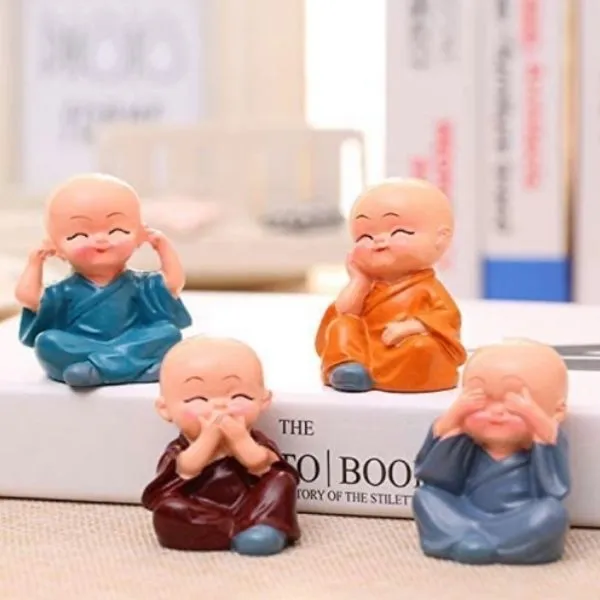 A Miniature Monks Assorted with cute expressions kept on a book with blur back ground.