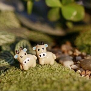 A cute and small Miniature Cows Assorted on artificial grass.