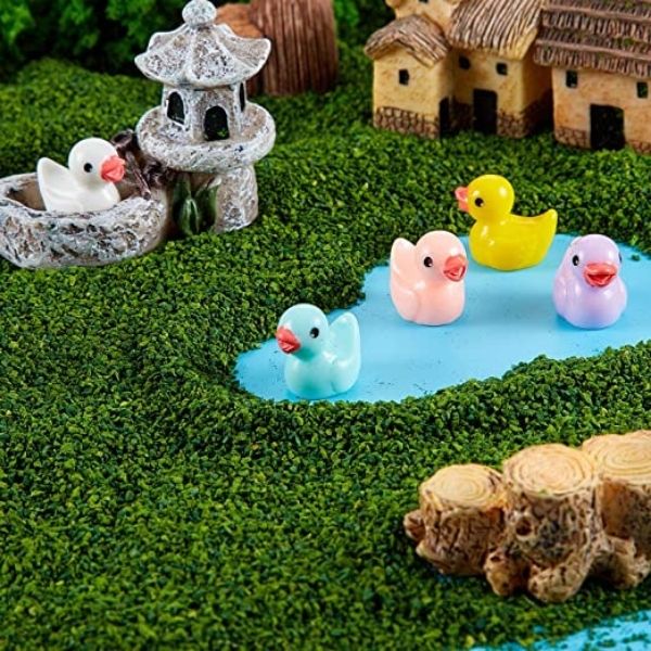Small and cute multicolor Miniature ducks decorated in a mini garden.