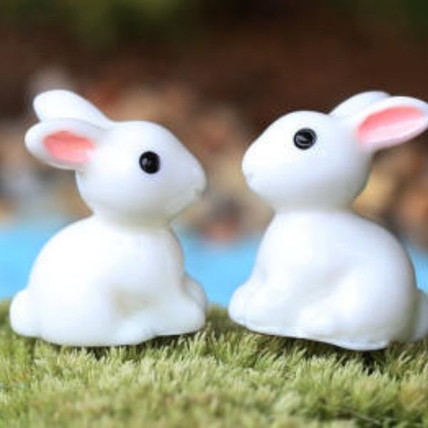 A cute and small pair of Miniature Rabbits on an artificial grass.