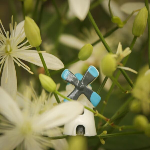A cute and small Miniature windmill is kept on the stem of a flower plant.