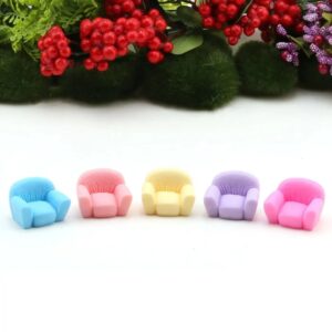 A cute multicolor Miniature Sofa/ Mini Sofa on a white floor with colorful flower and grass in the background.
