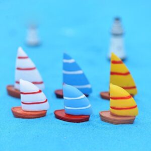 A cute multiple Miniature boat on a blue surface with blur background.