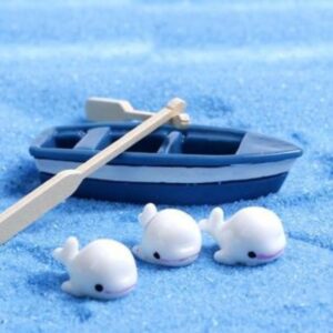 A cute and small Miniature white dolphin on a blue surface with miniature boat with oars in the background.