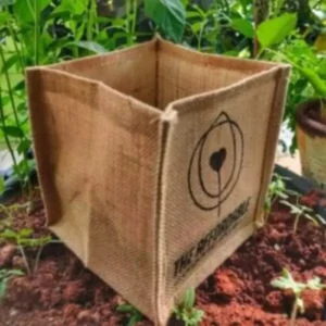 Image of Jute Grow Bags placed on mud with greenery in background.