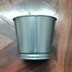 This is an image of Metal Bucket Pot kept against dark color background.
