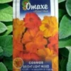 A packet of Omaxe Cosmos Bright Light Mixed Seeds in a green leafy background