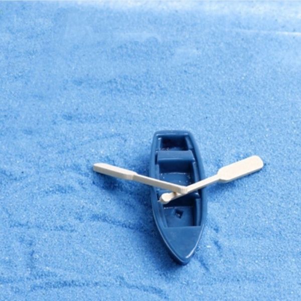 A beautiful and cute two Miniature boat with Oars on a blue surface.