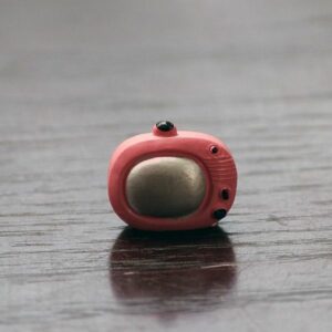 A cute Miniature Toy TV on a wooden floor.