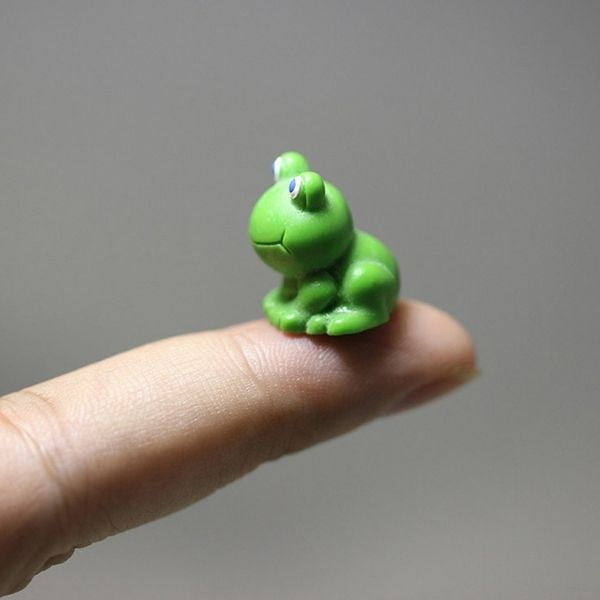 A cute left angles Miniature Toy Frog kept on a finger tip.