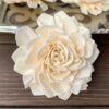 A beautiful flower made of natural sola wood on the table nxt to a tray with flowers on it.