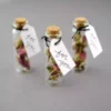 3 Vintage Seed Gift Bottles with cork containing seeds along with a thanksgiving card kept against grey color background.