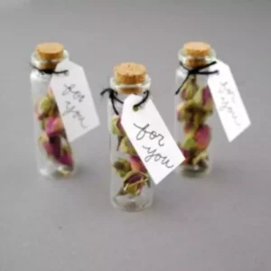 3 Vintage Seed Gift Bottles with cork containing seeds along with a thanksgiving card kept against grey color background.
