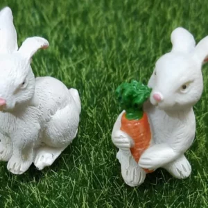 This is an image of two white color miniature bunny with greenery in background.