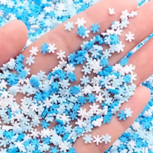 This is an image of Miniature Polymer Clay SnowFlakes placed on palm of hand.