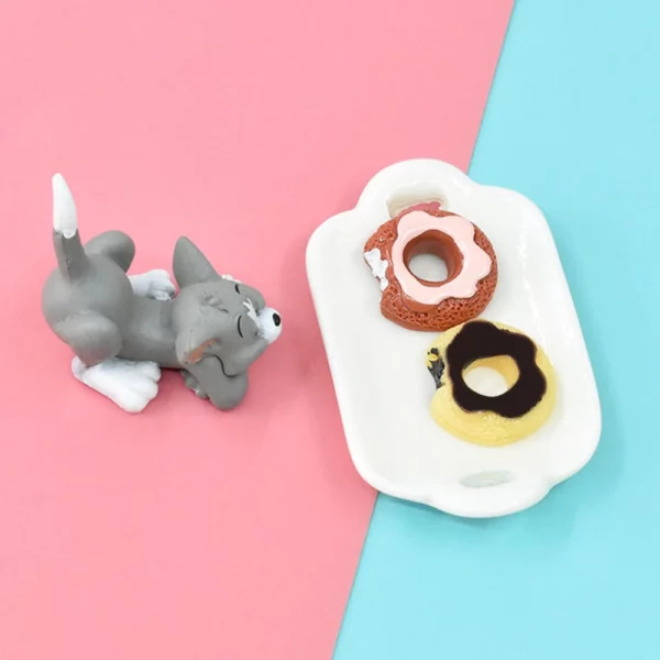 A Miniature Dollhouse Doughnuts kept on a small white tray upon blue and pink floor with toy cat beside it.