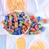 A collection of Miniature Dollhouse Soda Cans in a big bowl with colorful background.