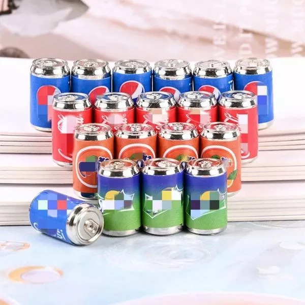A set of Miniature Dollhouse Soda Can which is kept on the floor.