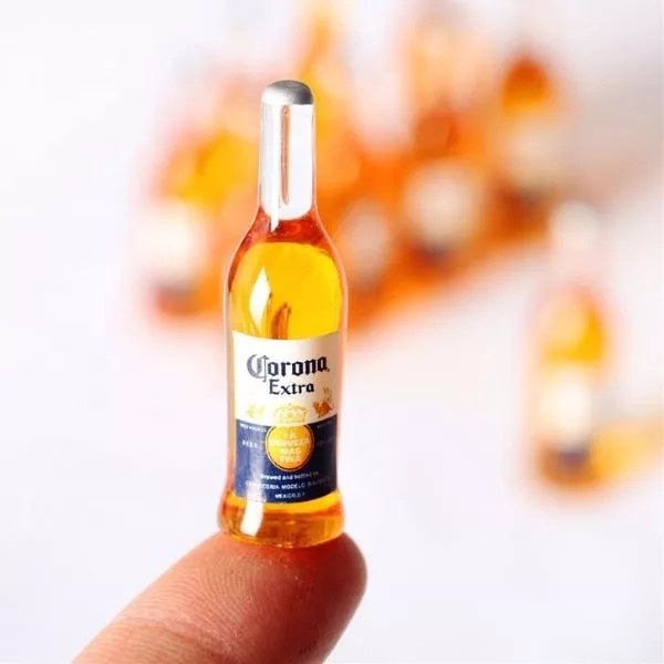 A Miniature Beer Bottle on a tip of a finger.