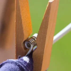 This is an image of multiple Wooden Clips hanging on a rope against a blur background.