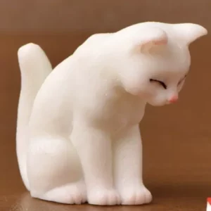 This is an image of white color Miniature Toy Cat against a brown background.