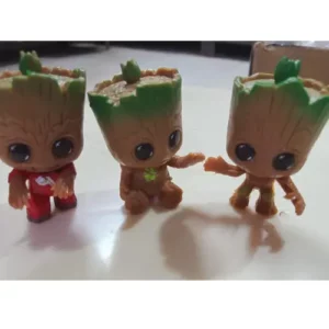 This is an image of three Miniature Groot kept above white color table.